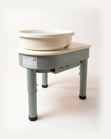 The Kiln Crafts Thistle direct drive pottery wheel in sage green with a cream top