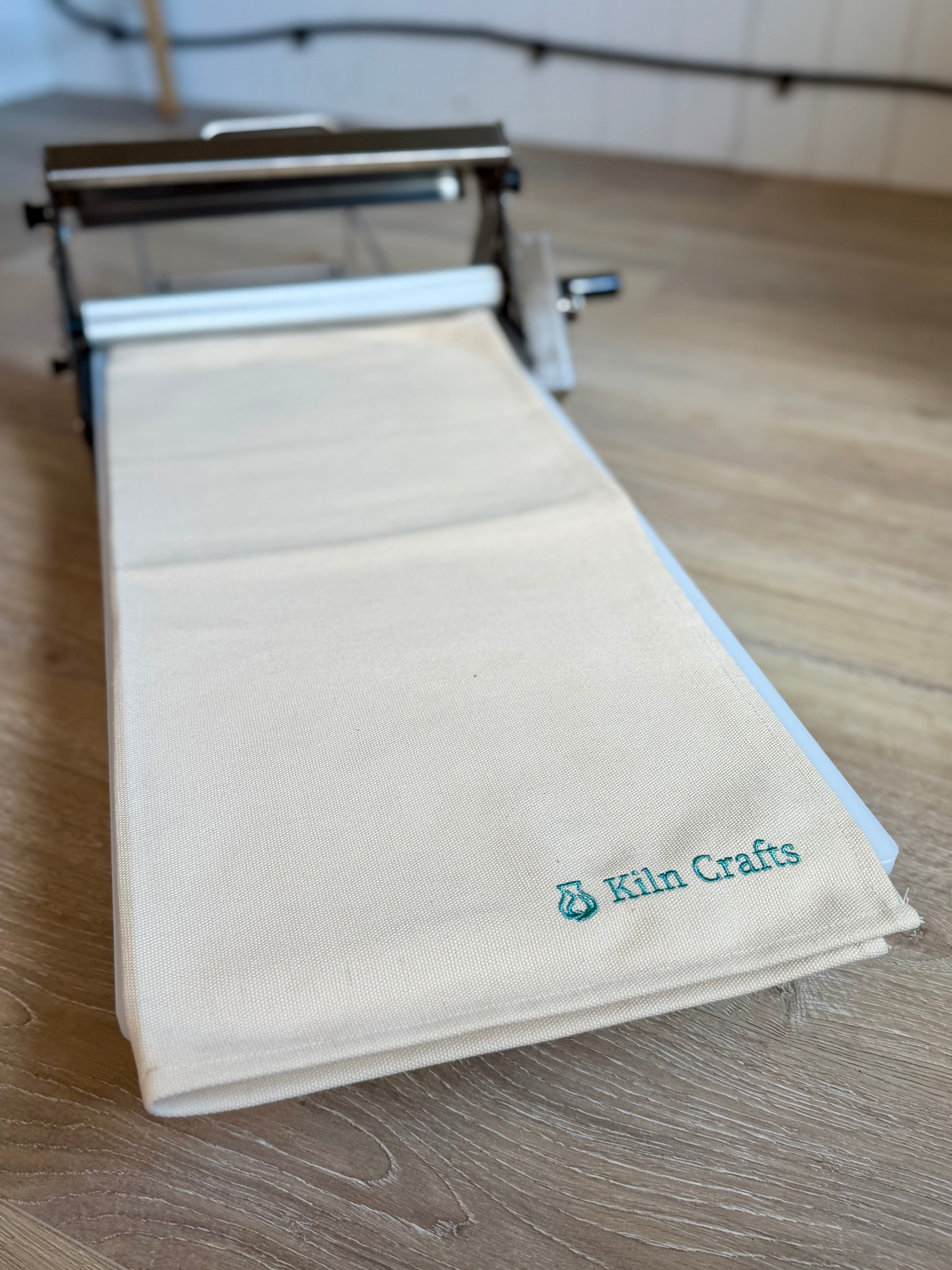 Table Top Clay Roller with canvas cloth feeding through the rollers
