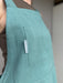 Close-up of the Teal Kiln Crafts Craft Apron chest pocket and woven Kiln Crafts label